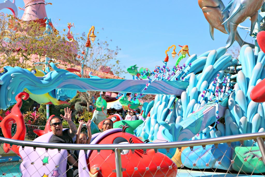 A dad and his girls on a fun ride at Seuss Landing. 