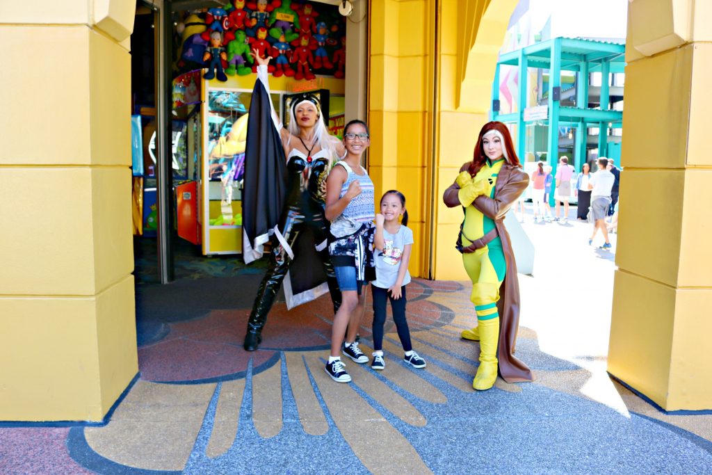 Two girls strike a pose with Storm and Rogue from X-Men.