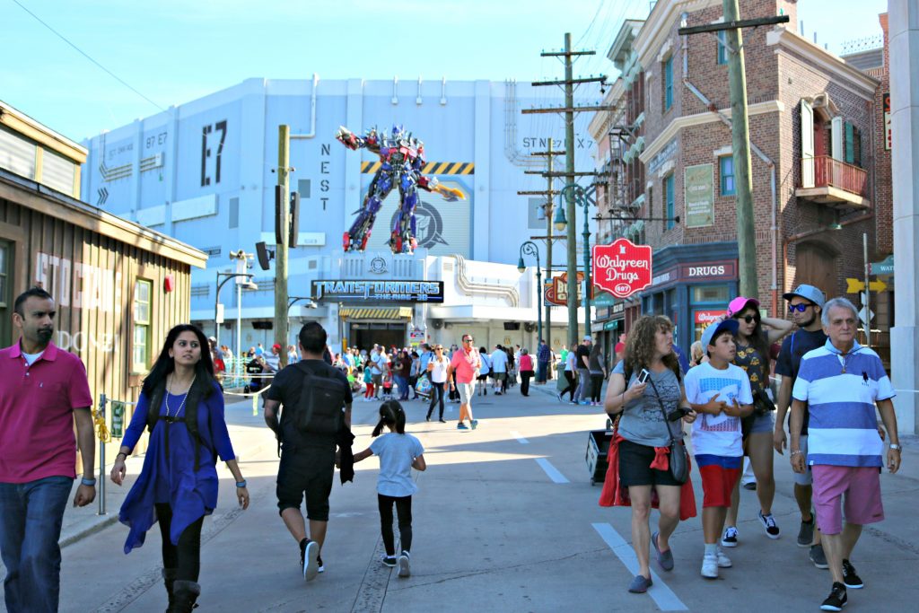People walk toward the Transformers ride at Universal Studios.