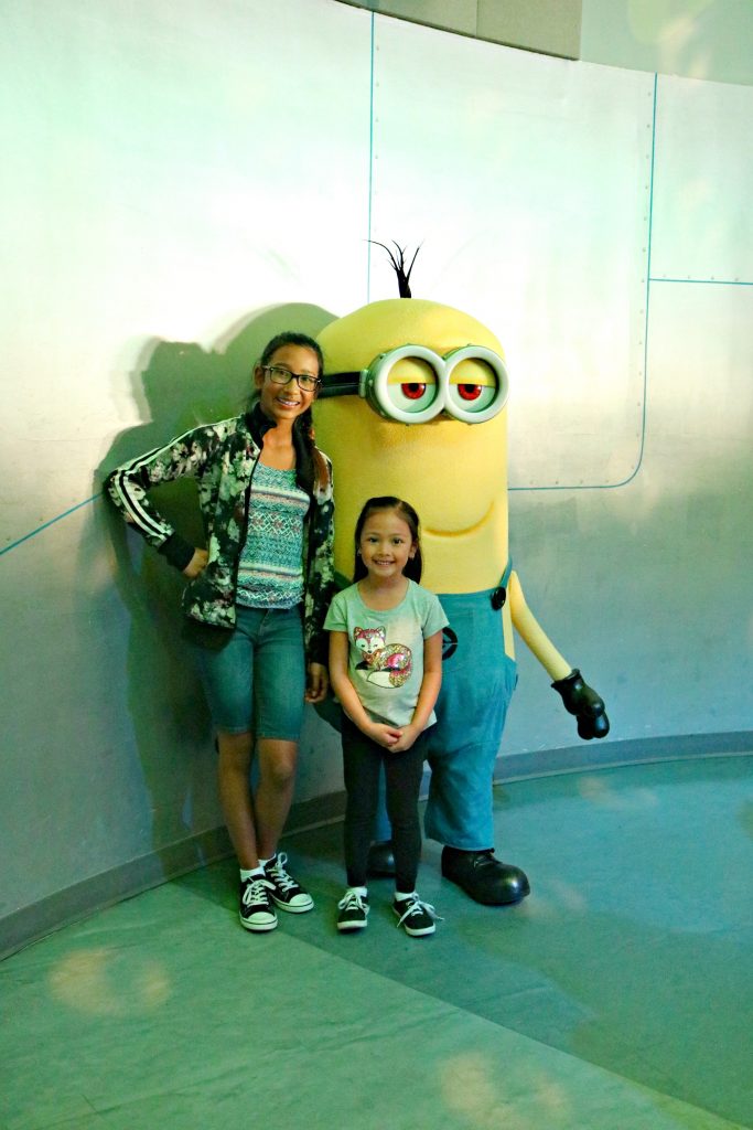 Two little girls pose with a minion from Despicable Me. 