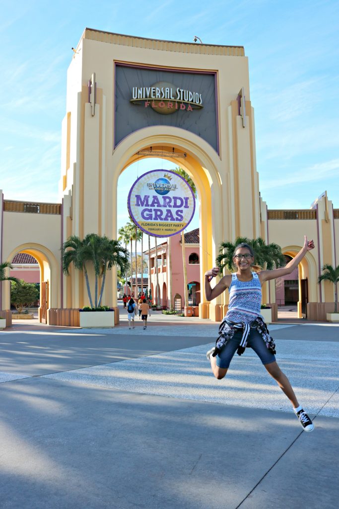 A young girl jumps in front of the Universal Studios entrance. 