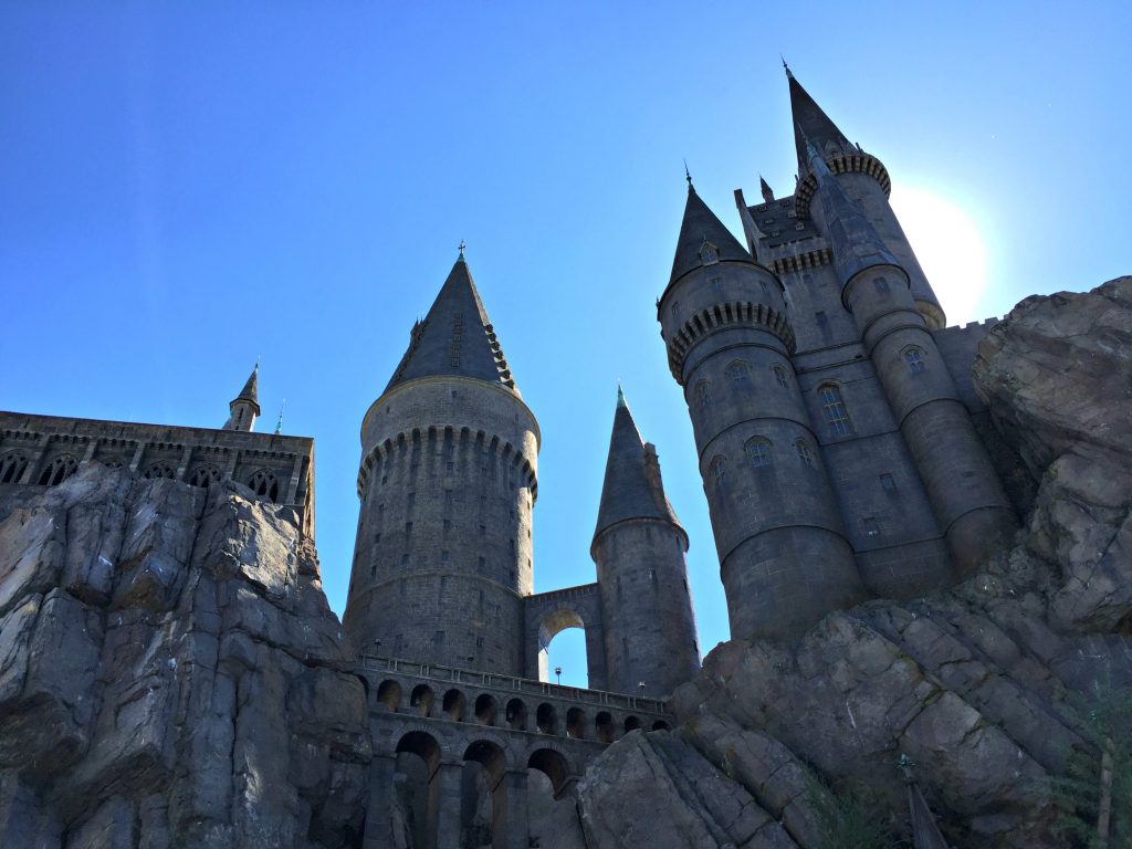 Hogwarts Castle with a blue sky and sun in the sky.