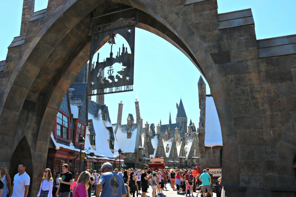 The sign of Hogsmeade and the people enjoying it.