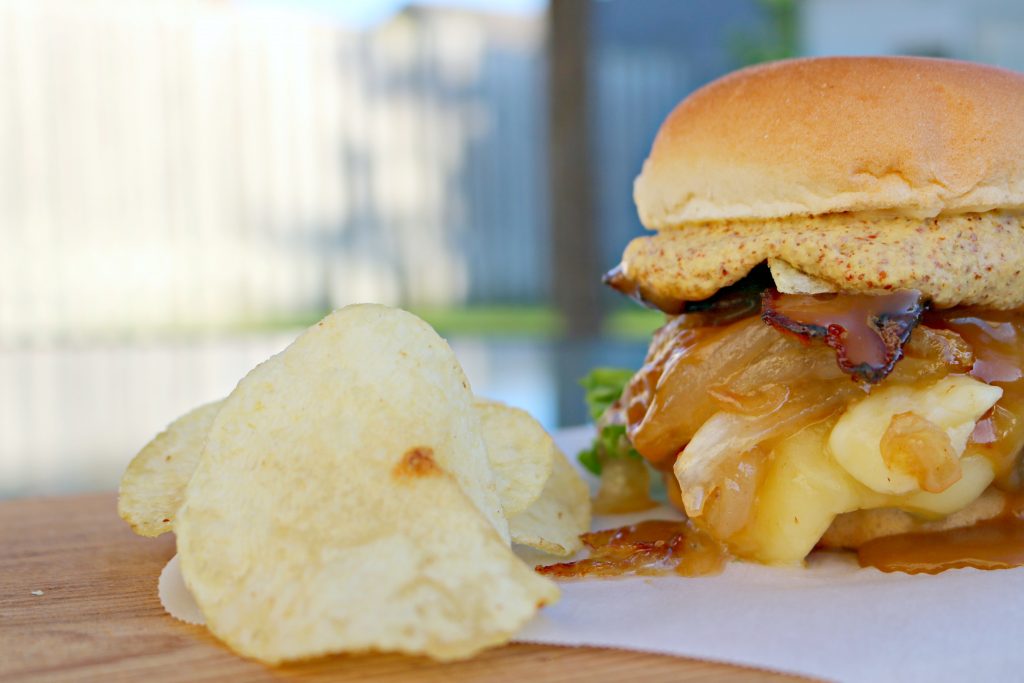 A close up of a potato chip and the burger is shown.