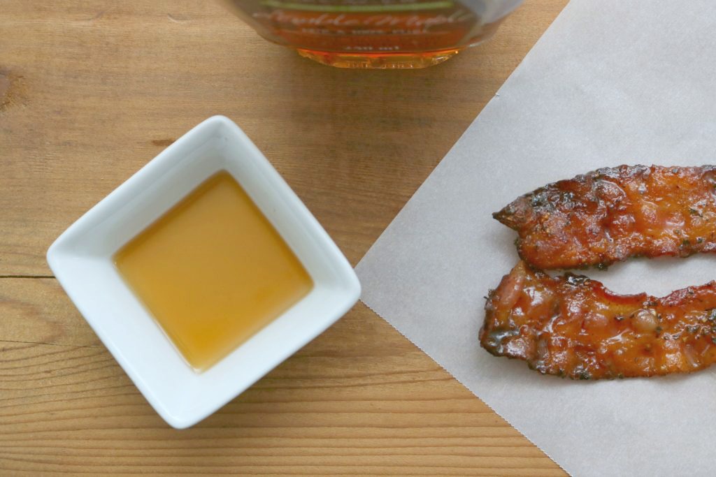 A top view of maple syrup and maple-syrup glazed bacon