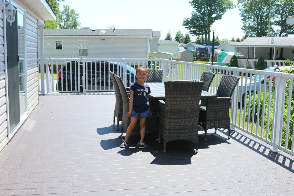 Mimi stands at the dining room set and smiles..