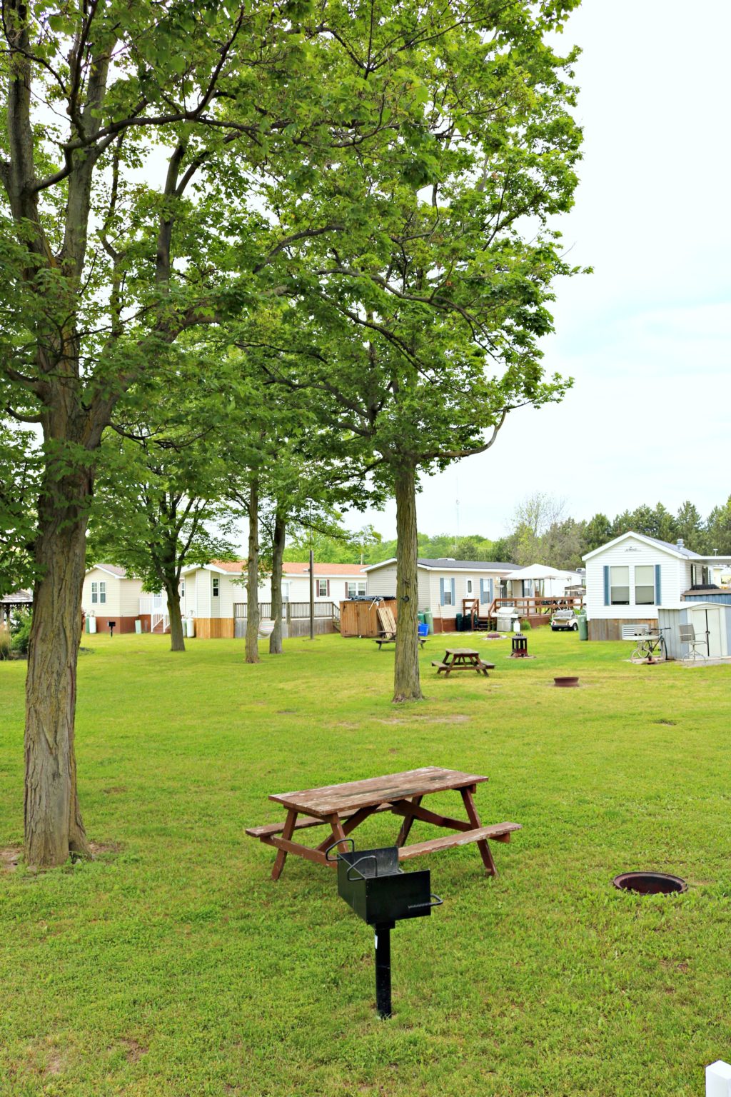 A view of the other Sherkston Shores properties with their designated picnic tables, BBQ, and fire pit.