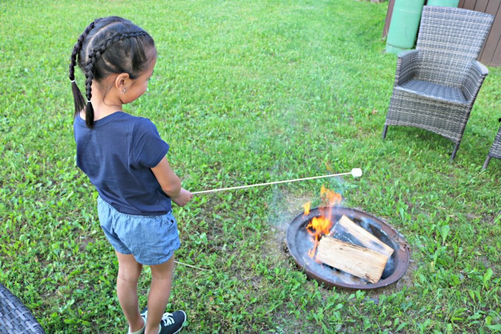Mimi roasting a marshmallow in the firepit.