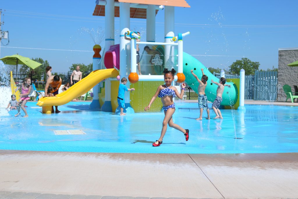 Mimi runs by while enjoying the water park. 