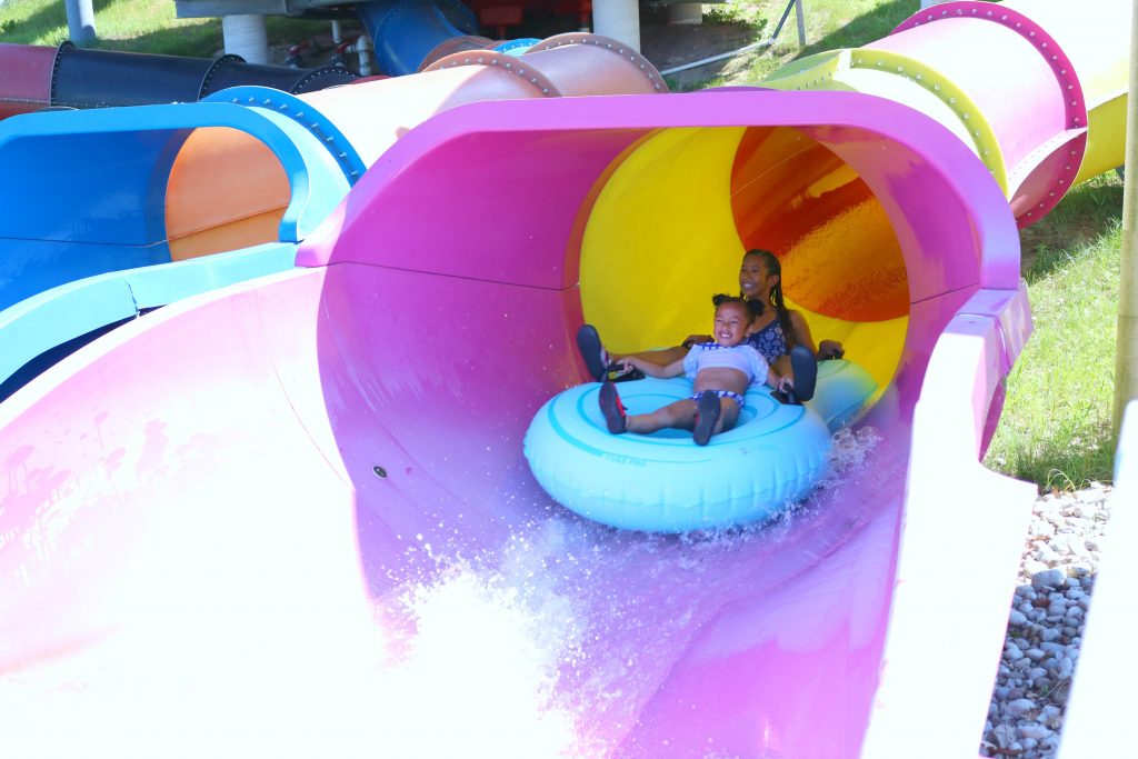 Mimi and Gabby going down another waterslide, with huge smiles. 