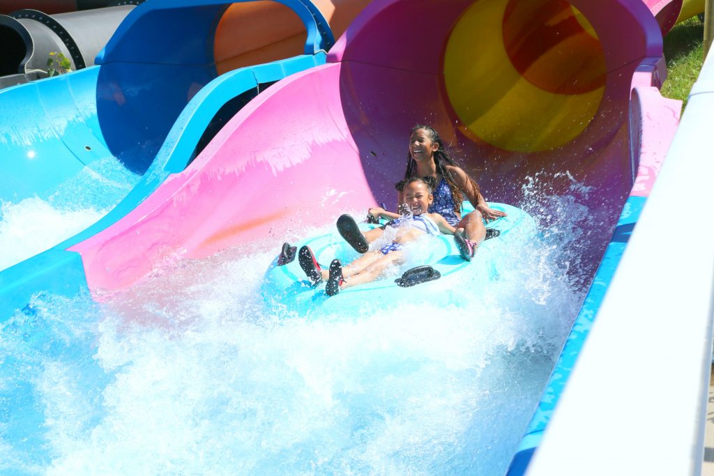 Mimi and Gabby splash out of the water slide.