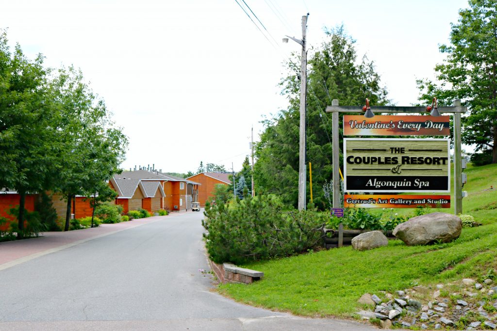 The entryway to the Couples Resort shows the sign atop a green hill. 