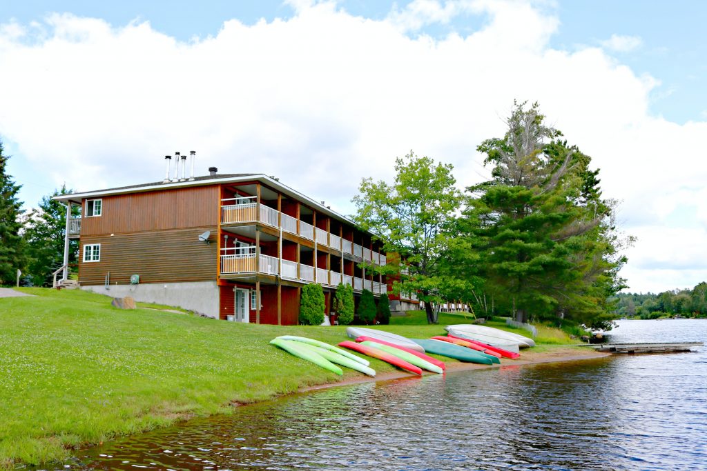 A final shot the canoes parked on the grass by the lake with the resorts in the background. 