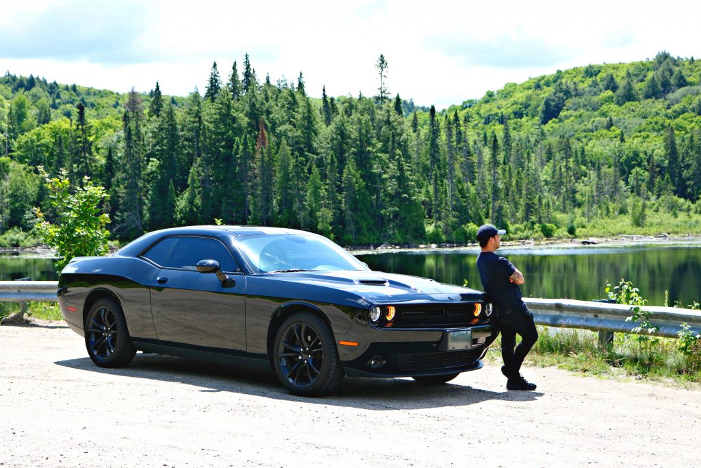 Darasak leans on his Dodge Challenger while he overlooks the lake. 