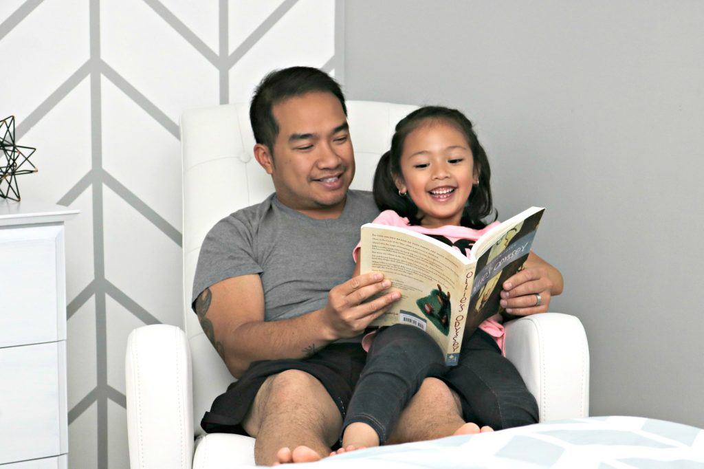 Mimi and Darasak laugh while they read a book on the recliner from Best Buy. 