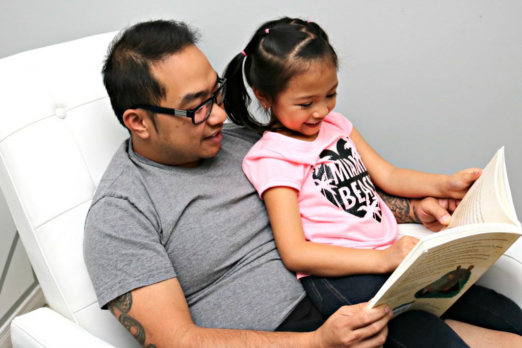 Close up of white recliner with Darasak and Mimi reading. 