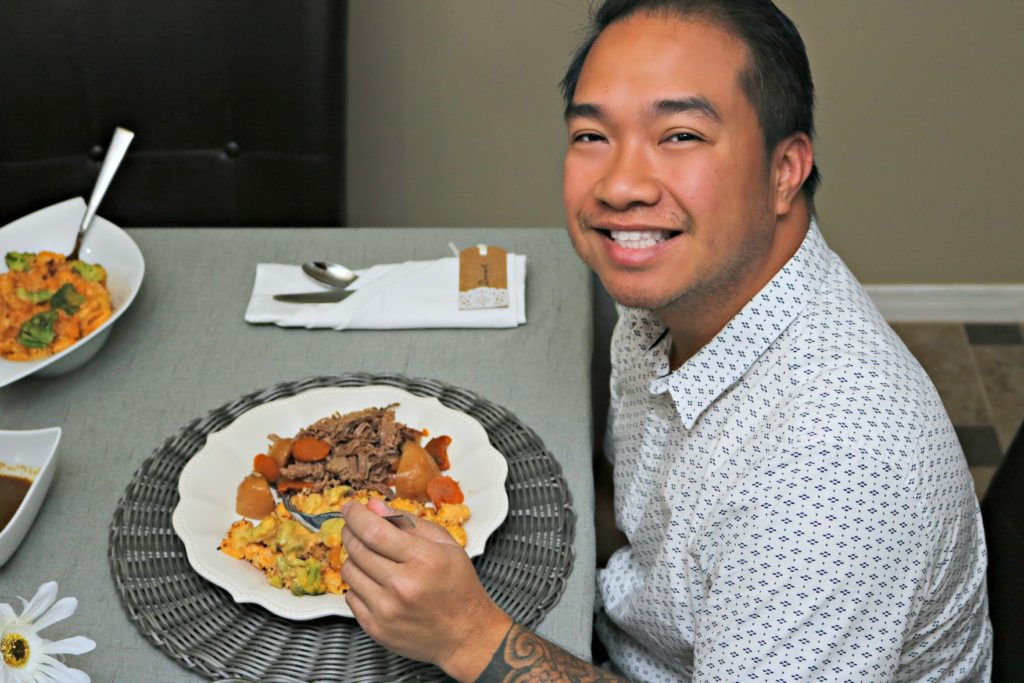 Darasak smiles at camera while eating his Thanksgiving dinner. 