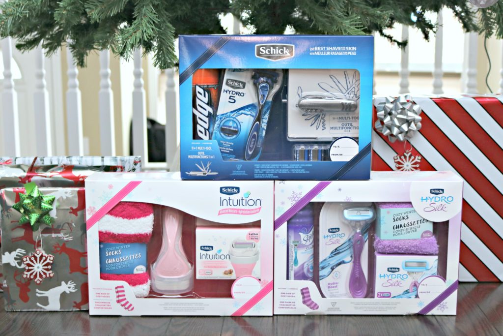 3 Schick Holiday Gift Sets are placed under the tree with other gifts. 