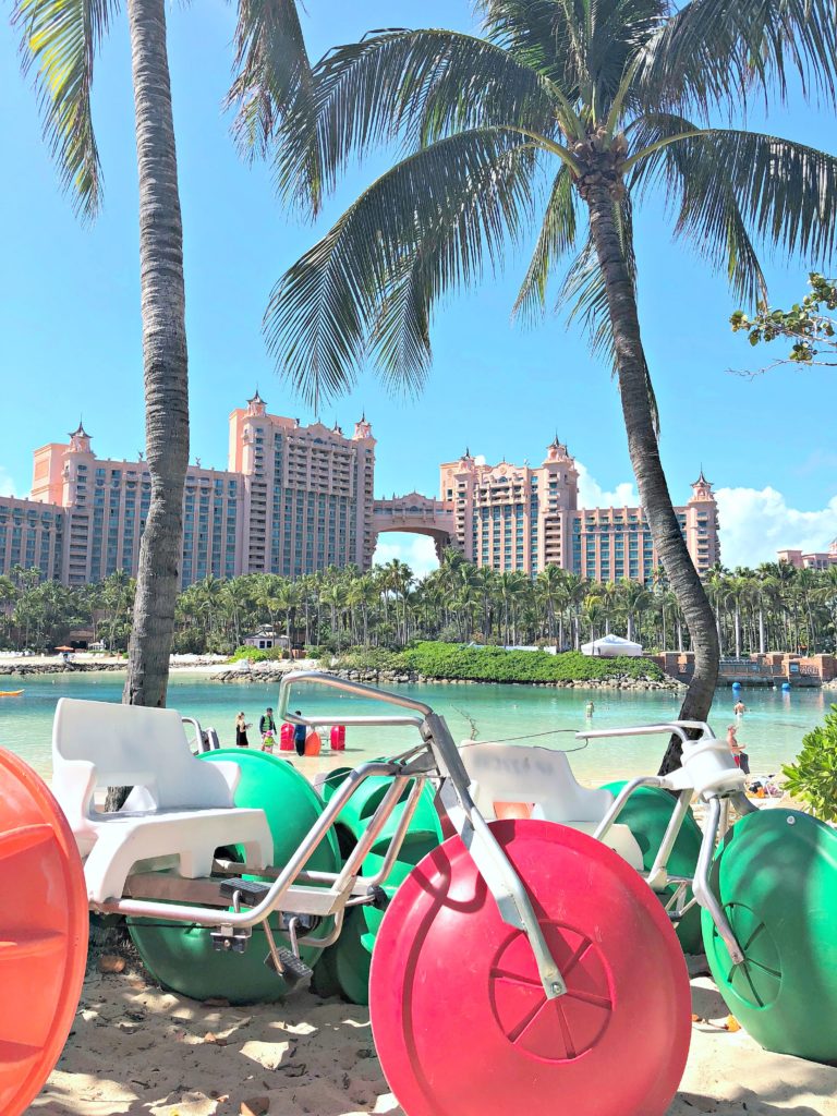 Atlantis resort is shown between palm trees while water trikes are underneath.