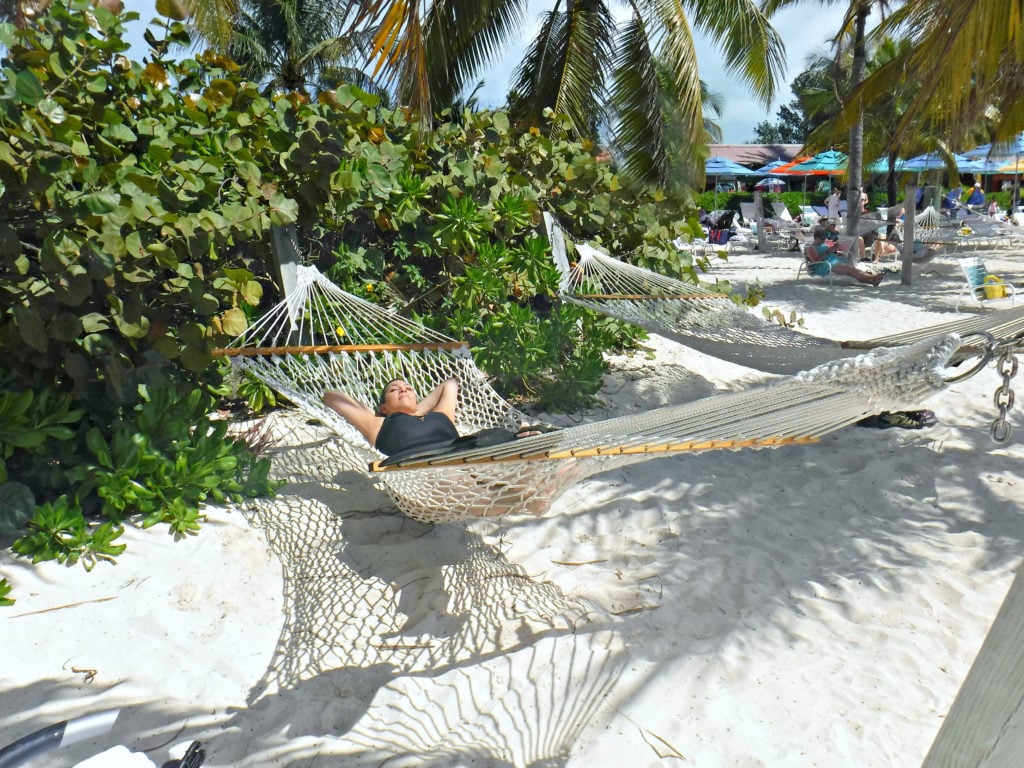 A woman lays in a hammock taking in the sand at Disney's Castaway Cay.