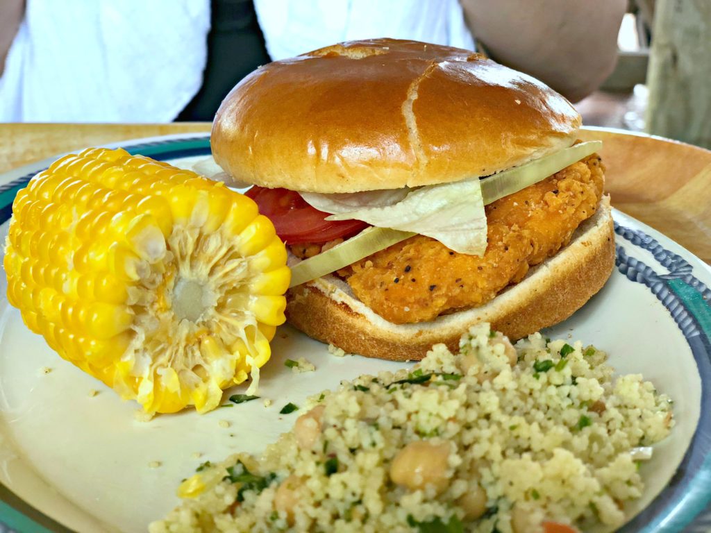 Spicy chicken sandwich at Castaway Cay with corn on the cob and tabouli. 