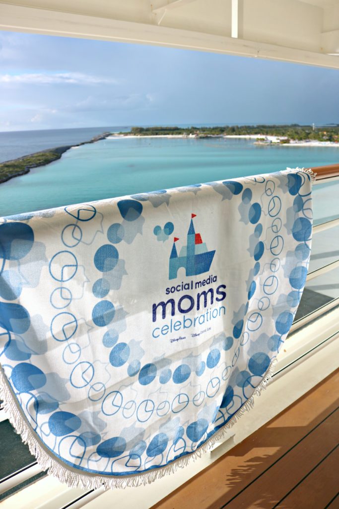 A #DisneySMMC beach towel hangs over the balcony ledge of the Disney Dream. 