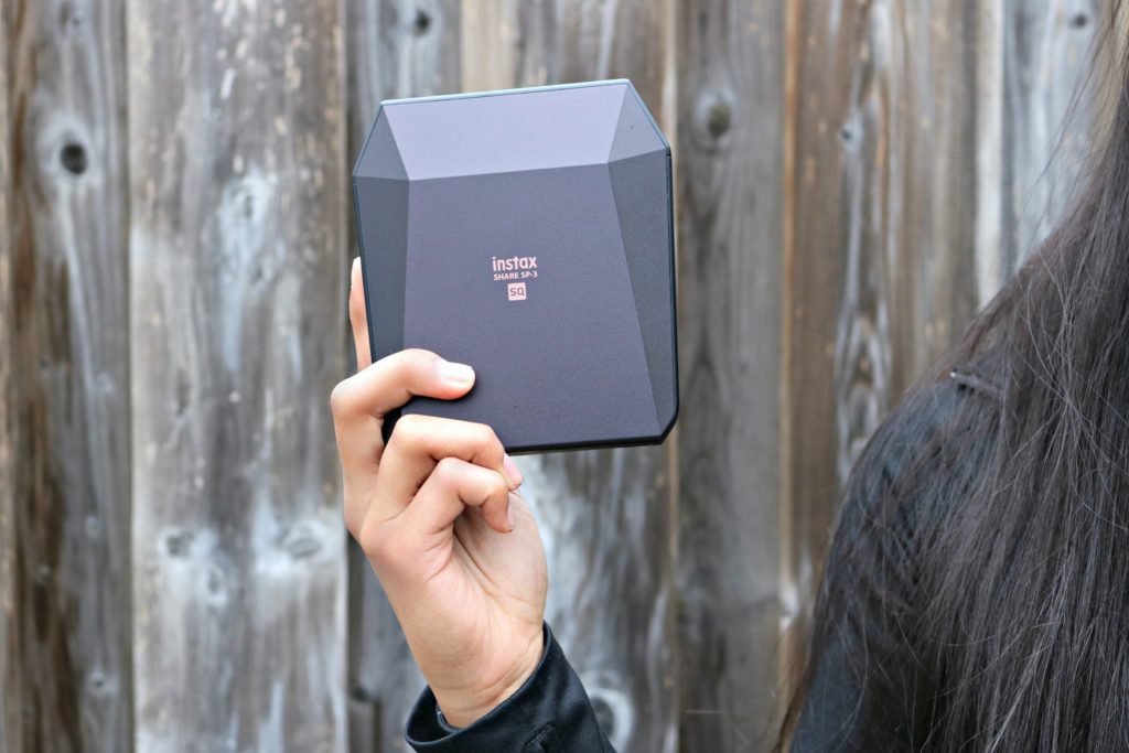 The Instax Square Share PS-1 printer shown by a teen. 