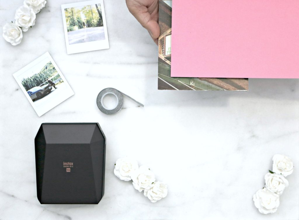 A printer with pictures, cardstock paper, flowers and tape are shown for a DIY project. 