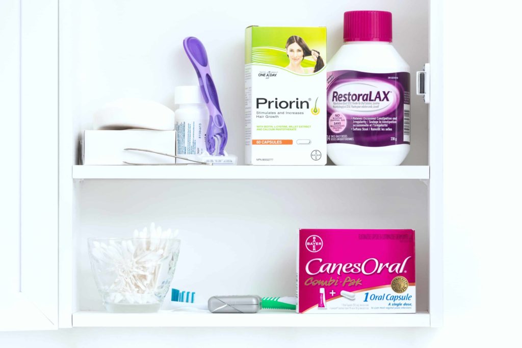 A medicine cabinet filled with essentials and RestoraLAX, Priorin, and CanesOral. 