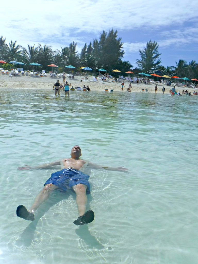 A man lies on his back in the beach of Serenity Bay.