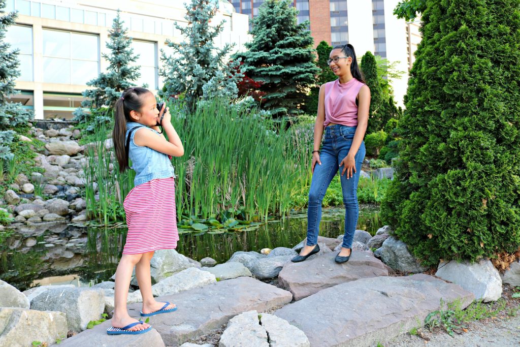 A little girl takes a picture of her older sister with the Instax Square SQ6.