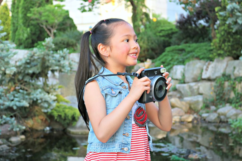 A little girl holds the Instax Square SQ6.