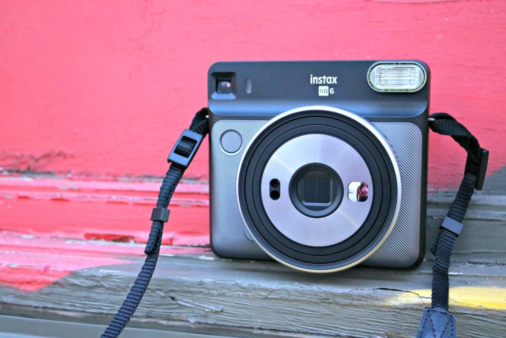 The Instax Square SQ6 in front of a pink wall. 