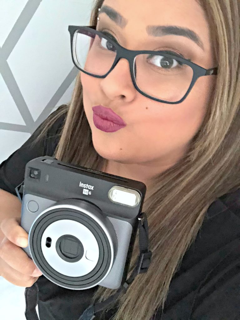 A woman is excited about her new Instax Square SQ6 camera. 