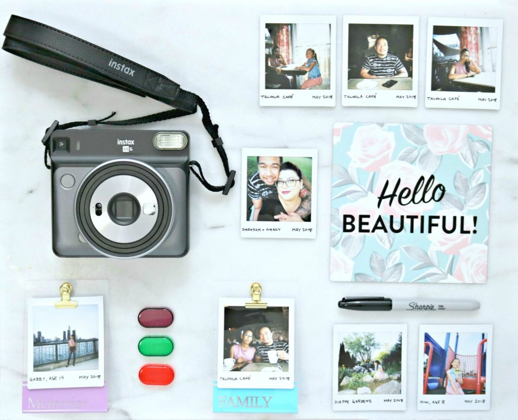 A flat lay of Instax prints, camera, sharpie and more.