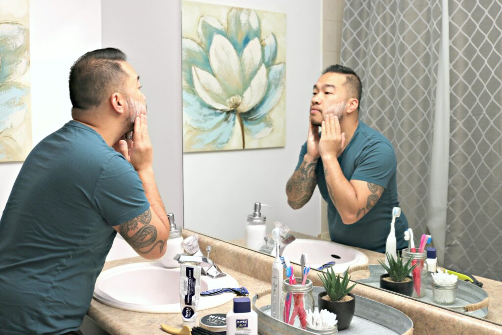 A man applies shaving cream to his face.