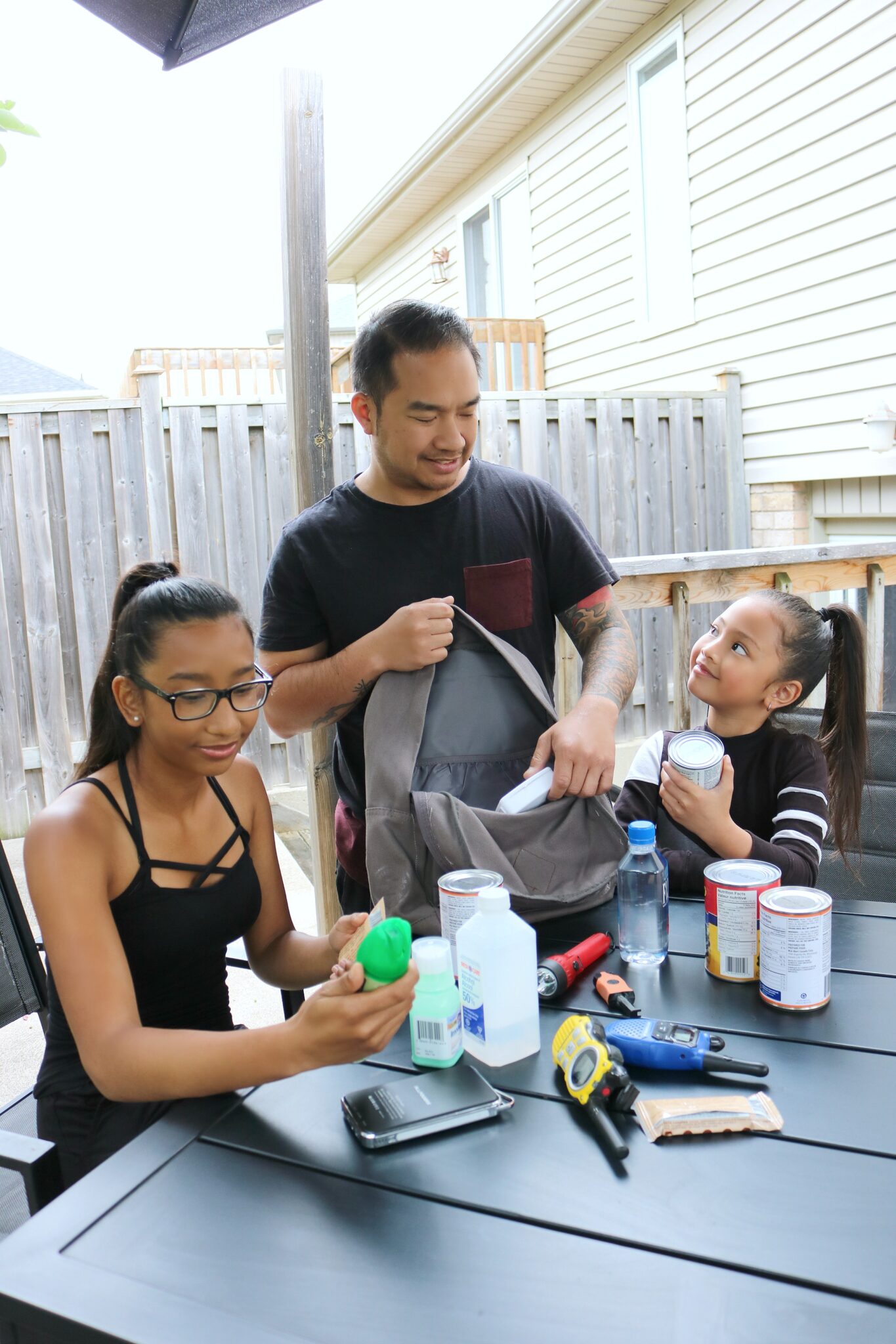 A family checks their emergency kit for expiration dates. 