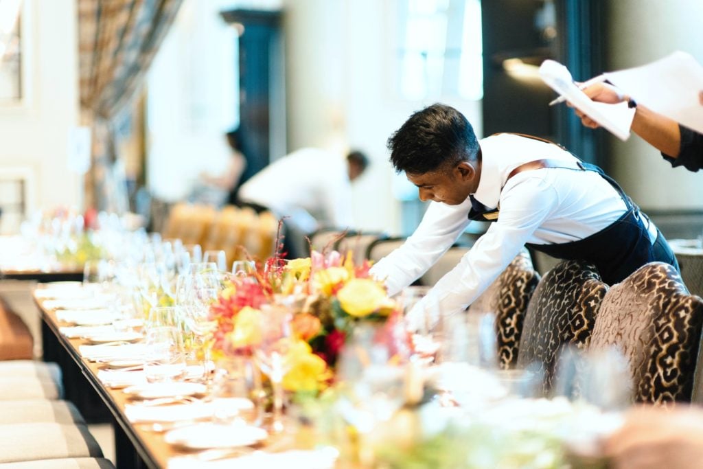 A caterer prepares the table at an event.