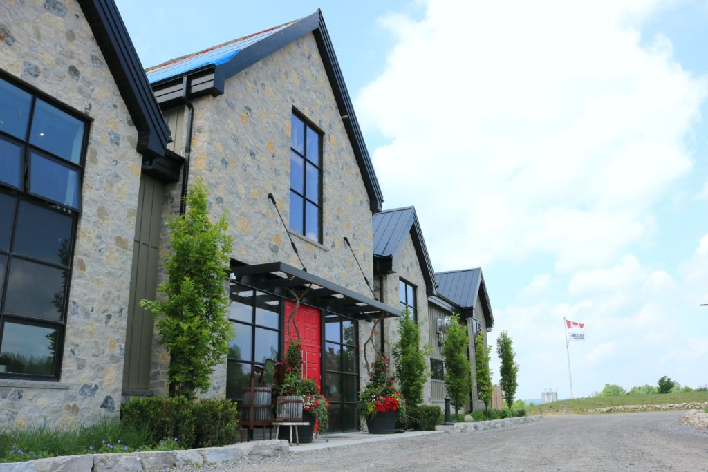 A side view of the winery, you can see the Canadian flag and Adamo flag flying in the background. 