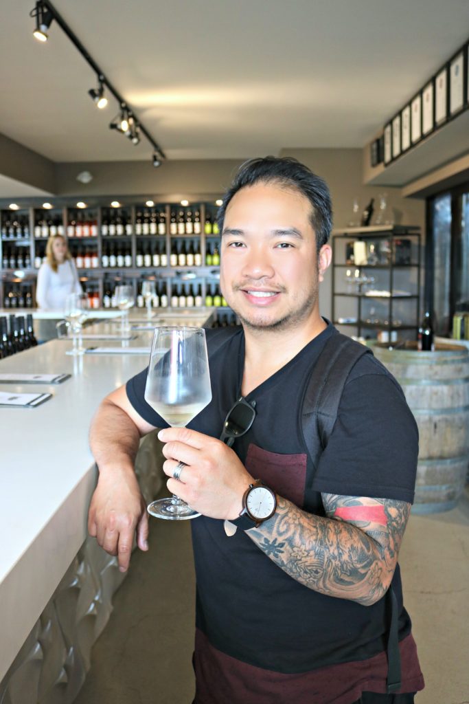 A man holds up a wine glass at the Adamo Estate Winery.