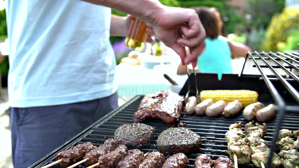 A man BBQ's meat on the grill. 