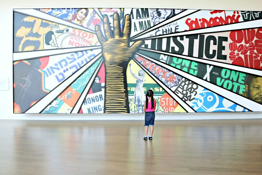 A little girl stands in front of a mural at the Center for Civil and Human Rights. One of many things to do in Atlanta.