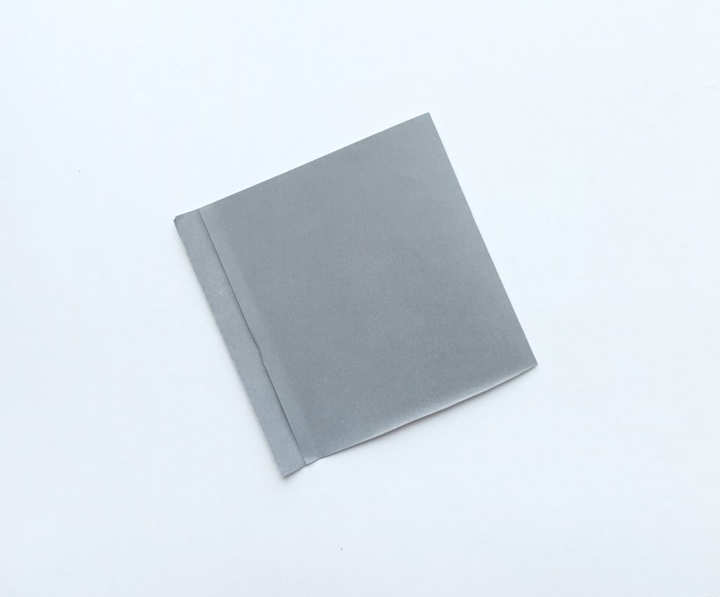 A grey piece of construction paper folded. 