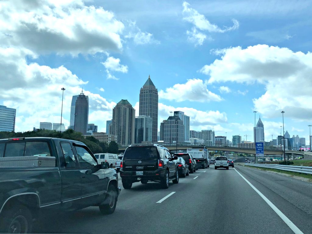 Cars in traffic against the Atlanta skyline.