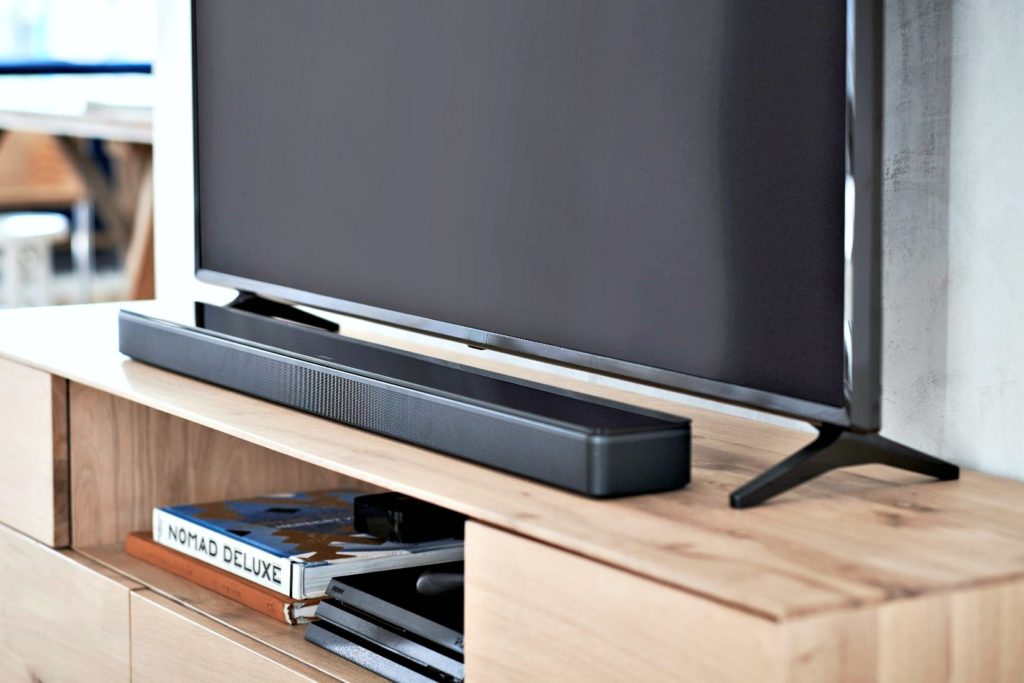 A Bose soundbar sits underneath a TV.