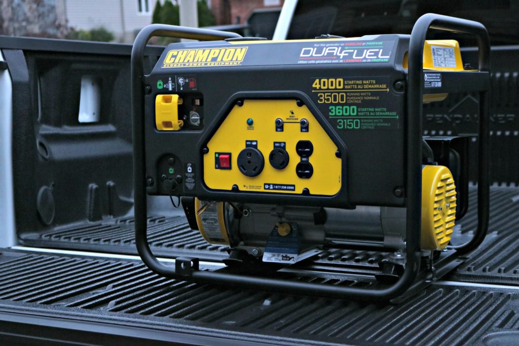 A Champion generator is being loaded on the truck bed.