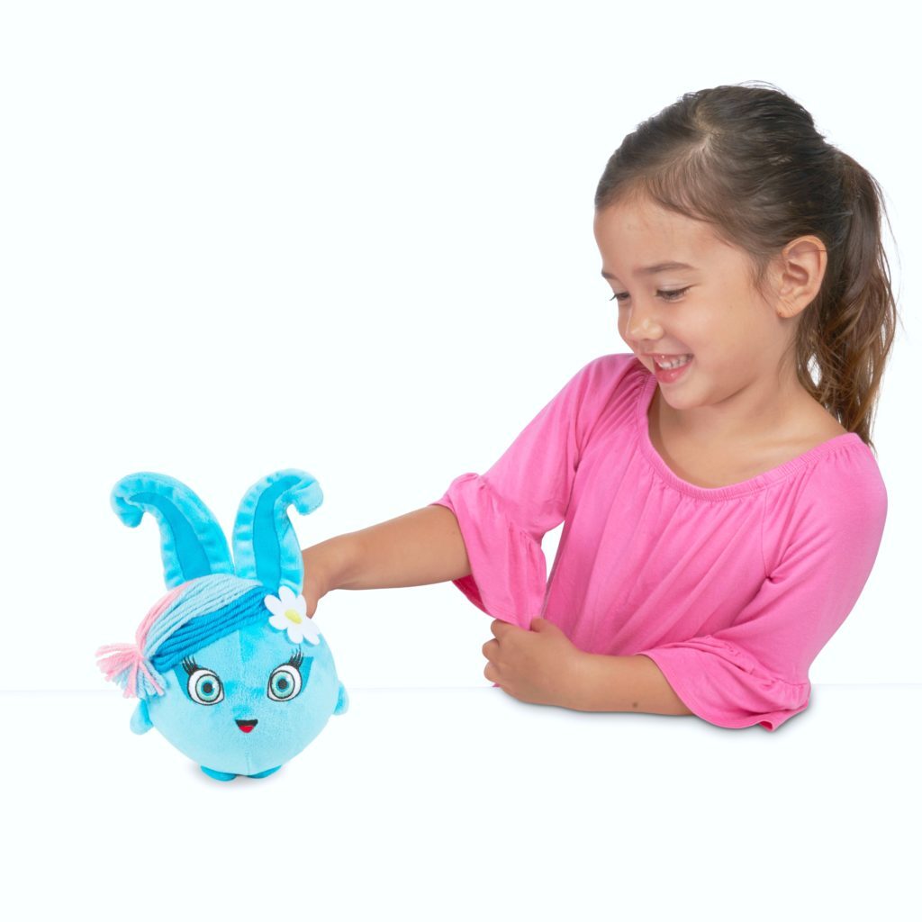 Little girl plays with a blue Sunny Bunny.