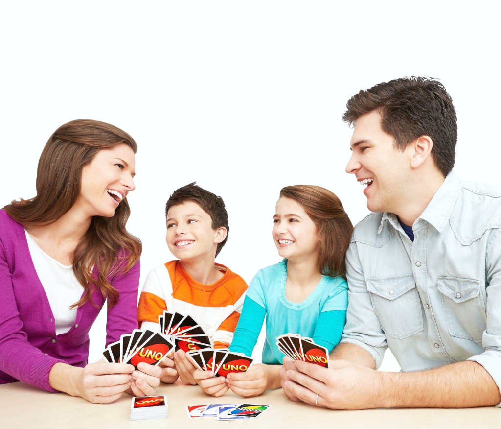 A family plays UNO and are having a blast and laughing. 