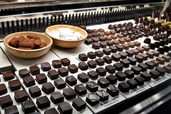 Row upon row of truffles and chocolate are shown in a display. 