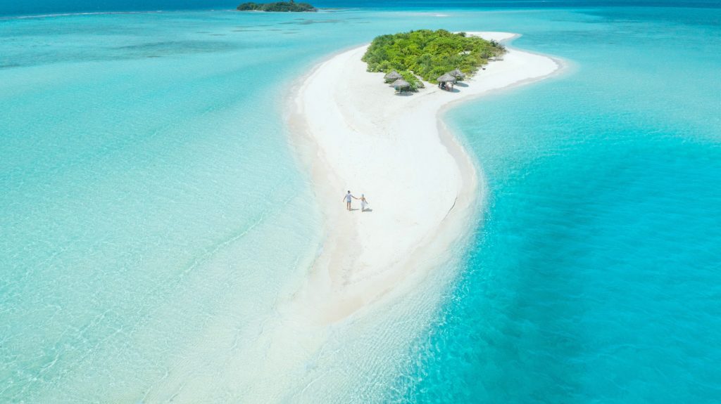 Couple walks on a deserted island in the Maldives. 